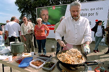 El candidato de IU, Fauto Fernández, cocina unas migas tras el acto electoral celebrado ayer en el pantano de Valmayor.