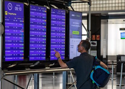 Un viajero observaba los paneles informativos en el aeropuerto de Barcelona este verano.