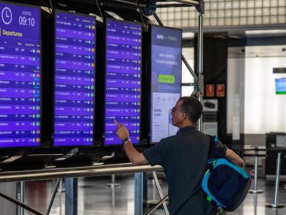 Un viajero observaba los paneles informativos en el aeropuerto de Barcelona este verano.