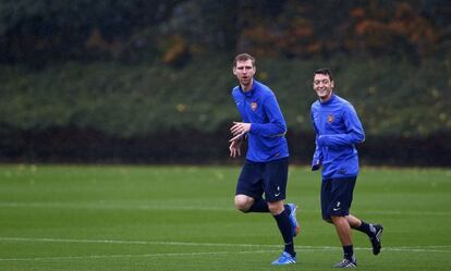 Los jugadores del Arsenal Per Mertesacker y Mesut Özil calientan durante una sesión de entrenamiento en el centro deportivo de Shenley, a las afueras de Londres.