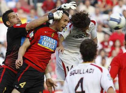 El sevillista Escudé, a la derecha, pelea el balón de cabeza con Ramis y Moyà.