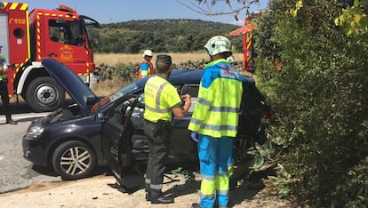 Un guardia civil y un sanitario observan el turismo siniestrado.