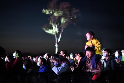 Un hombre sostiene a una niña durante un concierto celebrado bajo el cielo de Pekín el pasado lunes.