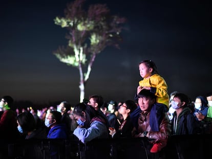 Un hombre sostiene a una niña durante un concierto celebrado bajo el cielo de Pekín el pasado lunes.