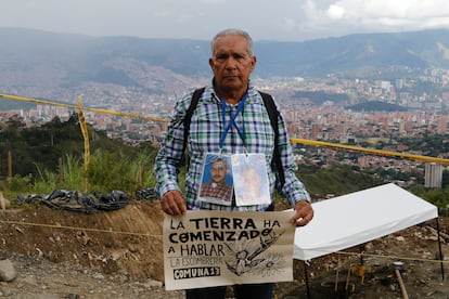 AME7475. MEDELLÍN (COLOMBIA), 26/12/2024.- Jorge Durán, familiar de personas desaparecidas durante el conflicto, sostiene un cartel mientras asiste junto a integrantes de la Unidad de Búsqueda de Personas dadas por Desaparecidas (UBPD) a una intervención forense en 'La Escombrera', en Medellín (Colombia). 