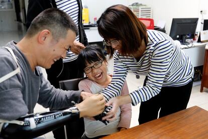 Engineer Chang Hsien-Liang (L), 46, fits a 3D-printed prosthetic hand, which he designed and built, on Angel Peng, 8, who injured her hand in a scalding accident when she was nine months old, in Taoyuan, Taiwan, April 6, 2017. REUTERS/Tyrone Siu        SEARCH "PROSTHETIC 3D" FOR THIS STORY. SEARCH "WIDER IMAGE" FOR ALL STORIES.
