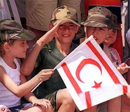 Un niño saluda mientras otro ondea una bandera turcochipriota, el viernes en la isla.