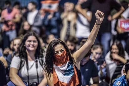 Una mujer se cubre el rostro con una bandera libanes, en una barricada en una manifestación en Beirut.