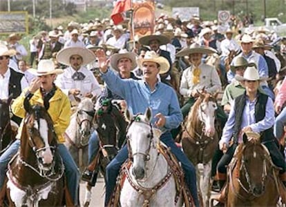 El presidente mexicano, Vicente Fox (centro), pasea a caballo por la localidad de Dolores durante las celebraciones del Día de la Independencia.