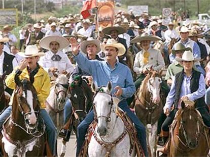 El presidente mexicano, Vicente Fox (centro), pasea a caballo por la localidad de Dolores durante las celebraciones del Día de la Independencia.