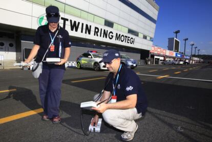 Dos técnicos miden el nivel de radioactividad del asfalto del circuito de Motegi.