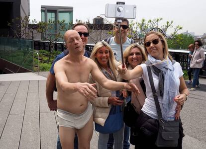 Un grupo de turistas posa con el Sleepwalker de Tony Matelli en el High Line neoyorquino.