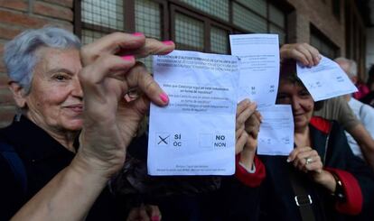 Varias mujeres muestran sus papeletas en un colegio en Sant Julià de Ramis.