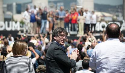 El presidente catalan, Carles Puigdemont (c), mira a la gente durante la lectura de un manifiesto independentista le&iacute;do por Josep Guardiola (al fondo).