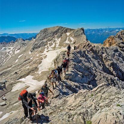Unos excursionistas caminan por un sendero en la cuerda de la monta&ntilde;a Zugspitze, la m&aacute;s alta de Alemania (2.962 metros), pero no la m&aacute;s elevada de Austria: el trazado que pisan los alpinistas separa un pa&iacute;s del otro.
