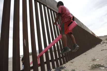Un niño juega en un balancín instalado entre la frontera de México y Estados Unidos, en Ciudad Juárez..