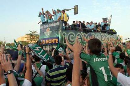 Los jugadores del Betis saludan desde un autobús descubierto a los hinchas en las calles de Sevilla.