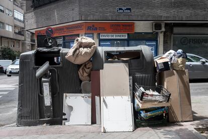 Un contenedor rebosante de basura ya a mediodía en el barrio de Salamanca, a la altura de Manuel Becerra.