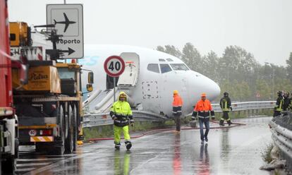 Varios operarios acondicionan una carretera después de que un avión de carga de la compañía DHL se saliera de la pista tras aterrizar de madrugada en el aeropuerto italiano de Bergamo (norte) sin que se produjeran víctimas y obligando a cerrar la instalación durante varias horas, en Italia.