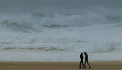 Una pareja pasea por Praia do Norte, en Nazaré (Portugal).