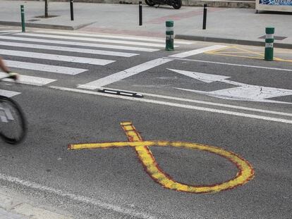 A yellow ribbon in Barcelona, which has been painted over with red paint to resemble a Spanish flag.