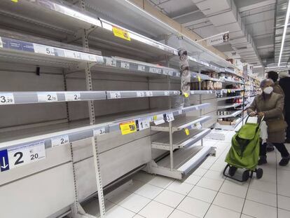 Una mujer observa unas estanterías vacías de legumbres en un supermercado de Madrid. 