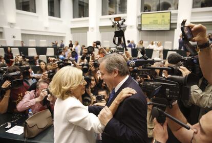 Manuela Carmena saluda al socialista Antonio Miguel Carmona a su llegada hoy al acto de investidura en Madrid.