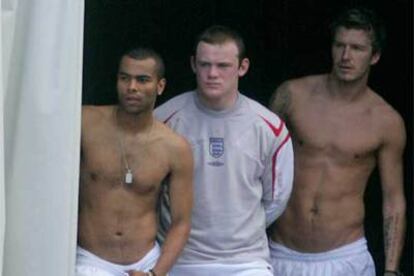 Cole, Rooney y Beckham observan el entrenamiento de ayer de sus compañeros.