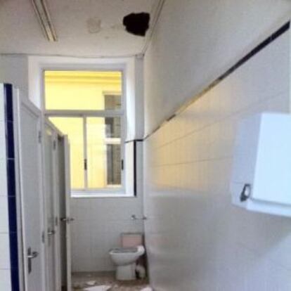 Aspecto de uno de los baños del colegio público donde el techo presenta daños.