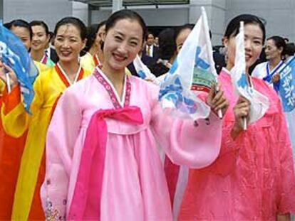 Un grupo de mujeres norcoreanas, con banderas de reunificación, en el aeropuerto de Incheon (Corea del Sur).