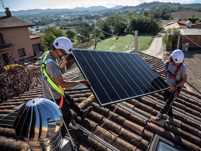 Unos operarios instalan unas placas solares en una casa de Barcelona.