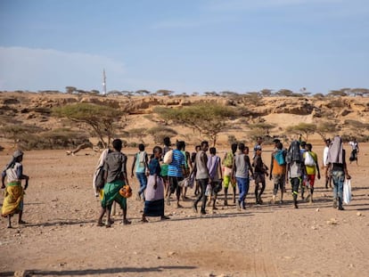 Migrantes etíopes en Obock, Djibouti, caminan hacia un área sombreada para esperar a que pasen contrabandistas y los lleven a Yemen en 2018.