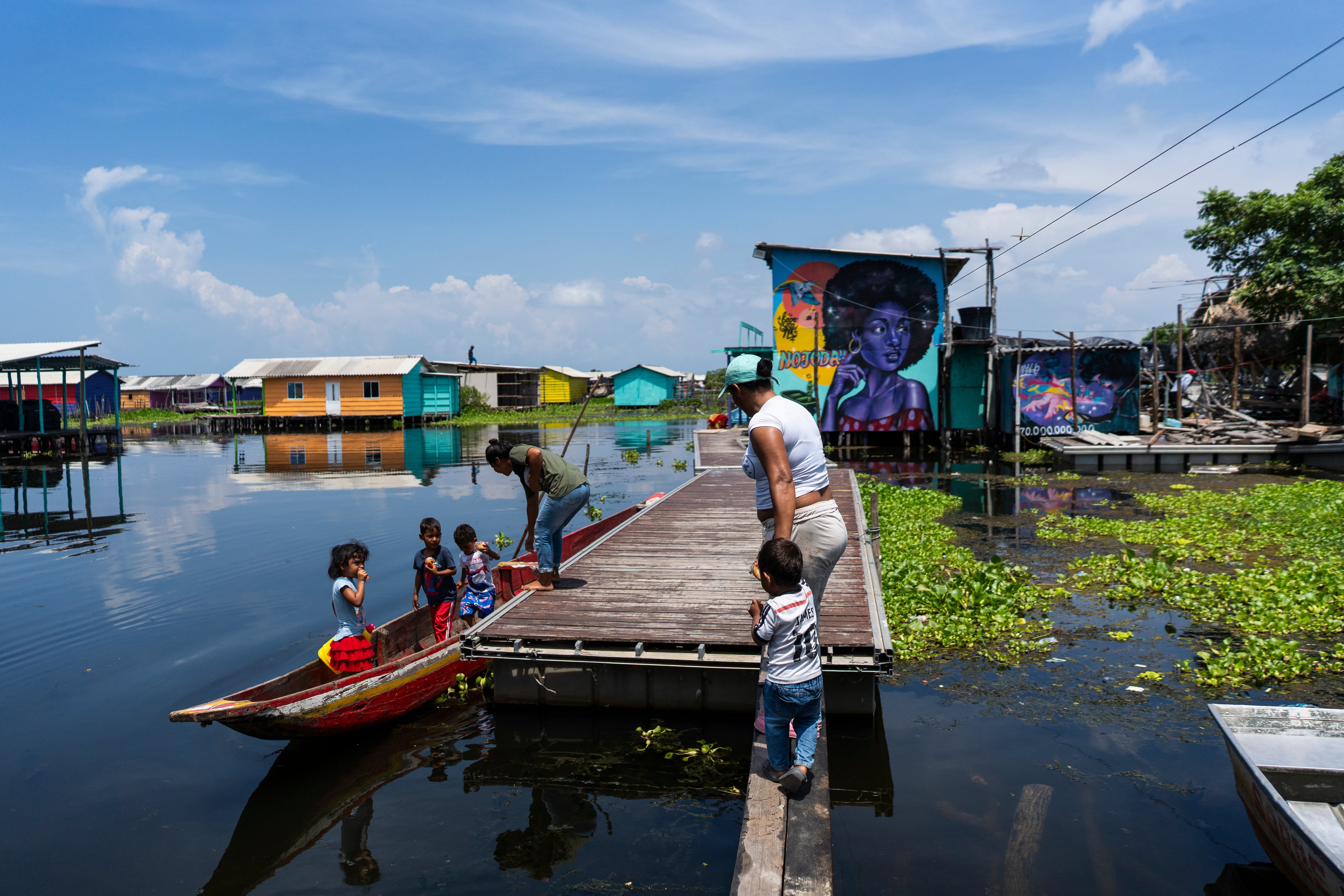 Una familia se prepara para navegar en canoa desde el muelle de Nueva Venecia.