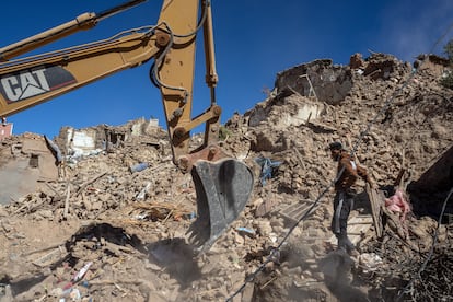 Una excavadora retira escombros de un edificio derrumbado por el terremoto en Douzrou (Marruecos).