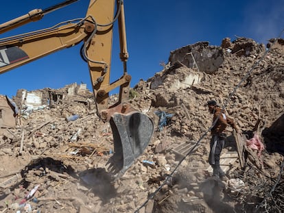 Una excavadora retira escombros de un edificio derrumbado por el terremoto en Douzrou (Marruecos).