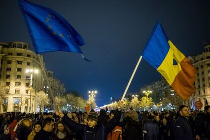 Un hombre porta una bandera de Rumania y otra de la UE, durante las manifestaciones antigubernamentales de febrero en Bucarest.