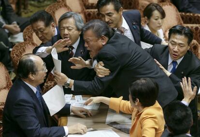 Un grupo de legisladores de la oposición se enfrenta al presidente del Comité Especial de Seguridad, Masaharu Nakagawa (i), durante una protesta tras la aprobación de una ley que impide a los medios publicar información clasificada, en el Senado en Tokio (Japón), 5 de diciembre de 2013. 