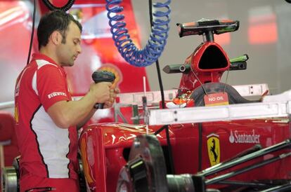 Un mecánico de Ferrari trabaja en el monoplaza de Fernando Alonso en el circuito de Cataluña.