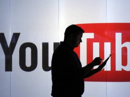 Un hombre pasa por delante del logo de YouTube.