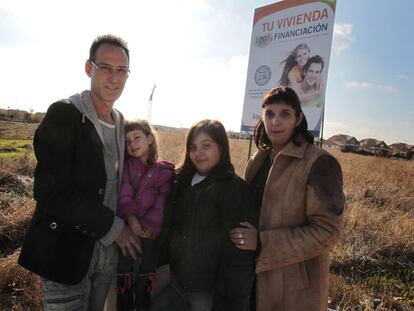 José Luis Blanco y Ruth Cuadrado, con sus dos hijas, junto al anuncio de una promoción inmobiliaria en Villanueva de la Torre.