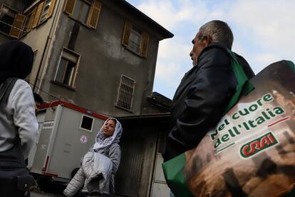 Varios migrantes de origen afgano pasan junto al puesto de socorro en el patio del centro de acogida de refugiados de Oulx, en el lado italiano de la frontera. En este lugar, una red de voluntarios ofrece algo igual de importante o más que el alimento y el refugio para los recién llegados: la atención sanitaria, incluida la vacuna contra la covid-19.