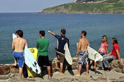 Unos surfistas contemplan la desembocadura de Urdaibai, en Mundaka, donde se producía la ola.