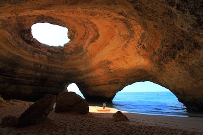 Benagil (Algarve, Portugal). La cueva de la playa de Benagil se eleva hacia el cielo a modo de cúpula gigantesca. Una ancha columna de luz solar penetra en el interior a través de una abertura del techo y confiere a las paredes un brillo anaranjado. A esta maravilla natural es posible llegar tanto nadando desde el mar como caminando desde la playa. También se puede subir hasta el techo escalando, eso sí, por los abruptos acantilados. Una vez arriba, se goza de unas vistas fantásticas del Atlántico y del paisaje costero en torno a Benagil.