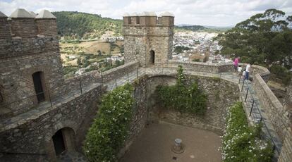 Una familia visita el castillo de Cortegana, con la poblaci&oacute;n al fondo y Portugal en el horizonte.