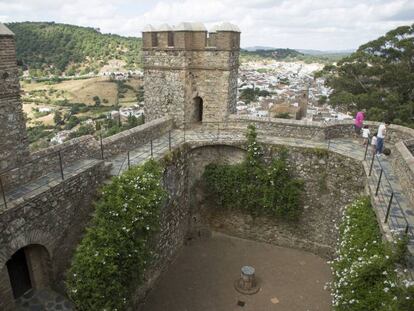 Una familia visita el castillo de Cortegana, con la poblaci&oacute;n al fondo y Portugal en el horizonte.