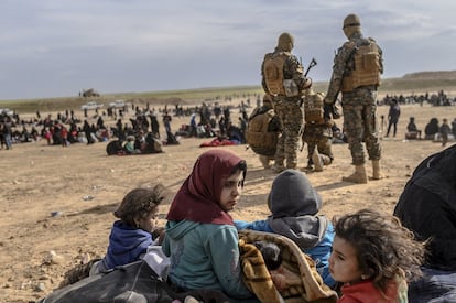Grupos de civiles, entre ellos numerosos menores, aguardan a ser registrados en el área para evacuados establecida por las milicias kurdas en la provincia siria de Deir Ezzor, el 5 de marzo. Este lunes, 11 de marzo, las fuerzas antiyihadistas frenaron su ofensiva al entregarse varios combatientes del ISIS que se hallaban en un campamento cercano a Baghuz.