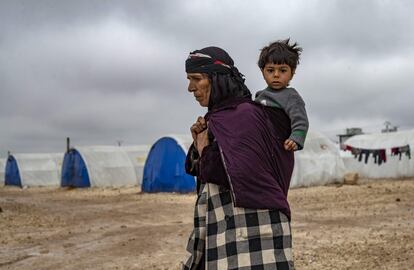 Una anciana lleva a un niño en el campamento para desplazados internos de Washukanni, cerca de la ciudad predominantemente kurda de Hasakeh, en el noreste de Siria.