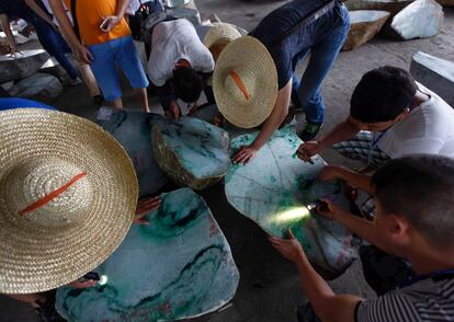 Compradores comprueban la calidad de las grandes piedras de jade en la exposición anual de la piedra de gema en Naypyidaw.