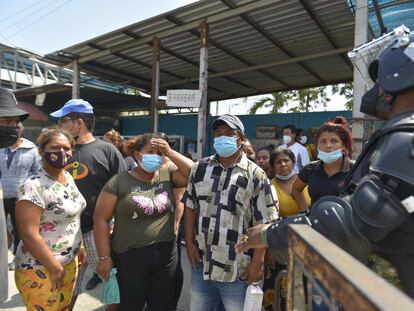 Parentes de presidiários mortos aguardam informações do lado de fora da prisão de Guayaquil, nesta quinta-feira.