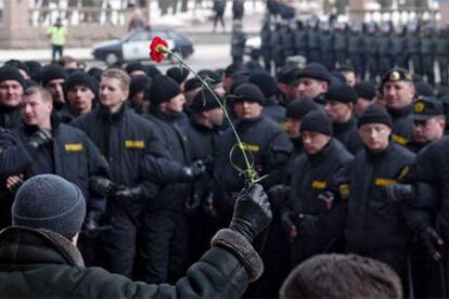 Un manifestante bielorruso sostiene un clavel frente a la policía durante una marcha de protesta en el centro de Minsk.